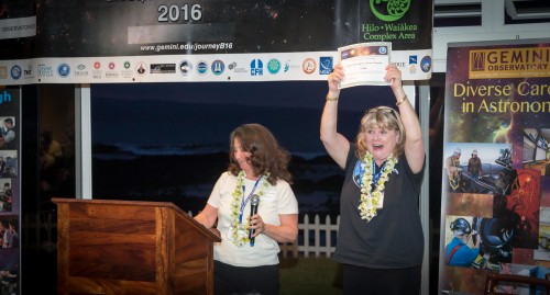 NASA Solar System Exploration Research Virtual Institute (SSERVI) Director Yvonne Pendleton (left) handing Journey Through the Universe program coordinator Janice Harvey a significant donation to the Journey Through the Universe program from NASA SSERVI.