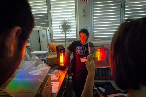 Barnes encouraged students to investigate how the light from assorted gas lamps are broken up into a rainbow of colored bands when viewed through a filter.