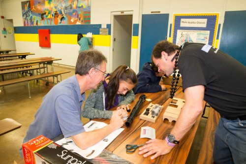 Sparks assisting another group in putting together their Galileoscope.