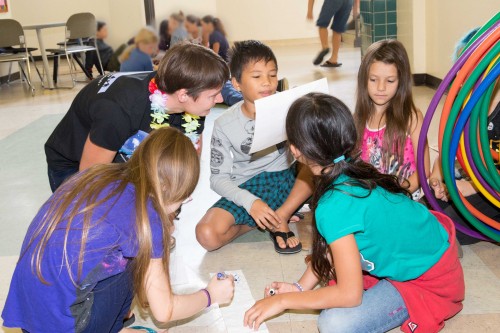 Gemini Astronomer Rachel Mason models the relative distances to the planets in the "Toilet Paper Solar System" activity with 3rd grade students at Connections.