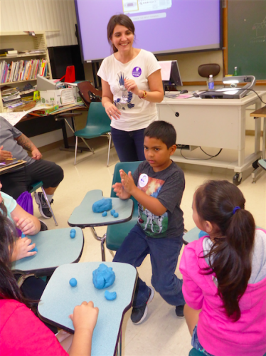 Petric instructs children in making celestial bodies like the Earth, Moon, and Sun to model their relative sizes and distances from one another.