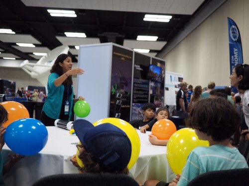 Gemini outreach intern Alyssa Grace shares the concept of the expanding universe with a group of students at the International Astronomical Union meeting currently ongoing in Honolulu.